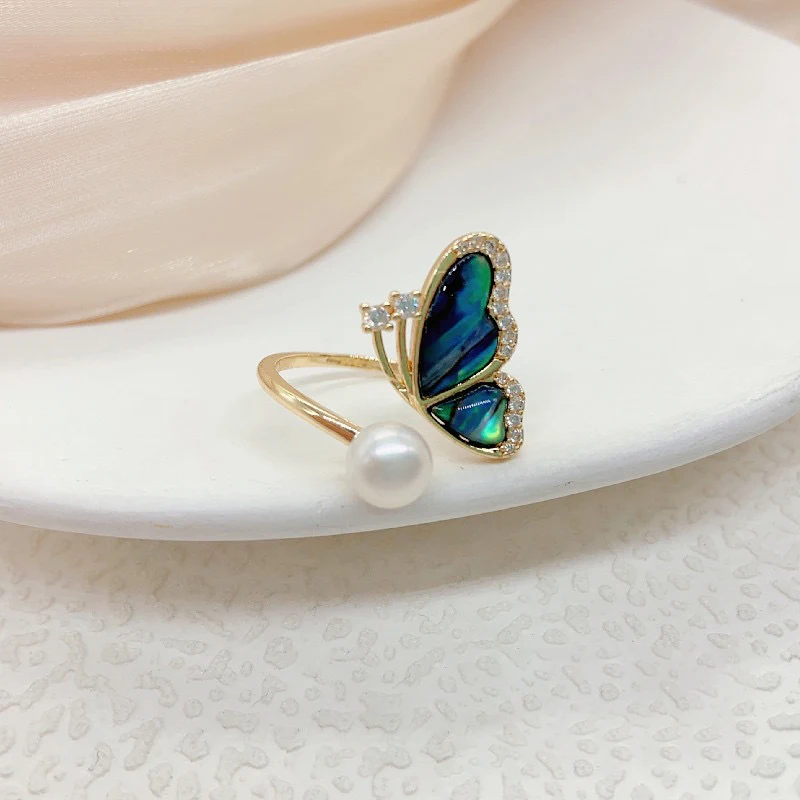 Bague de mode réglable avec perle d'eau douce et motif papillon pour femmes. Élégance et raffinement pour toutes les occasions. Un bijou parfait.