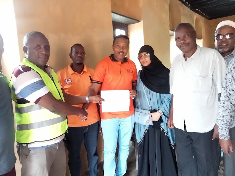 Ahmed Bunu Haji of ODM accompanied by his wife and party officials, receives his clearance certificate from Lamu county IEBC coordinator Maro Ade.