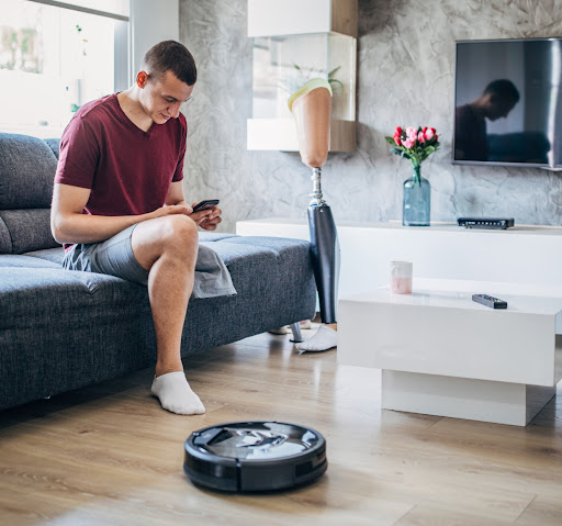 Un homme dans un salon contrôlant un aspirateur avec son appli Google Home