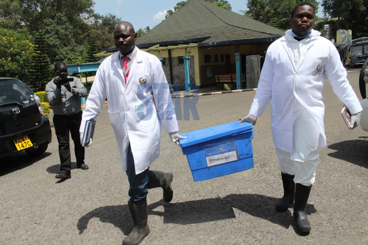 DCI forensic officers carry autopsy kit after Sergeant Kipyegon Kenei's postmorterm at the Chiromo Funeral Parlour.