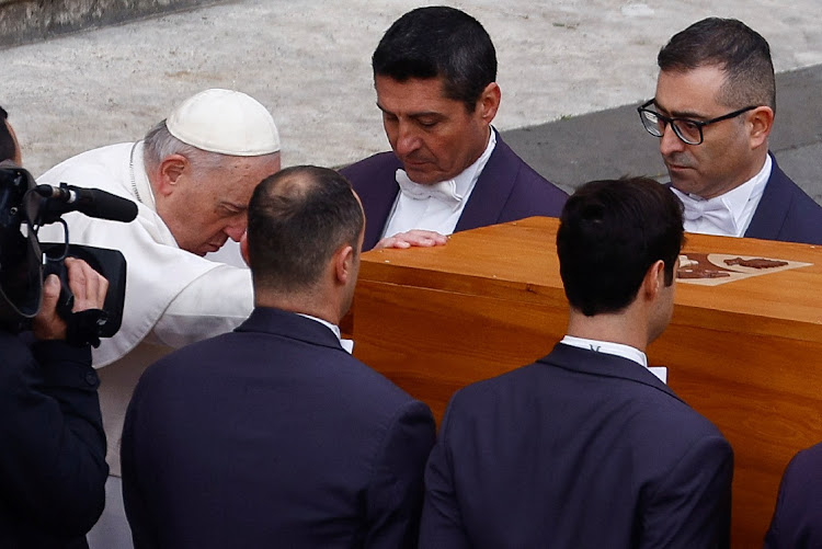 Pope Francis touches the coffin of former Pope Benedict during his funeral, in St Peter's Square at the Vatican, January 5 2023. Picture: GUGLIELMO MANGIAPANE/REUTERS