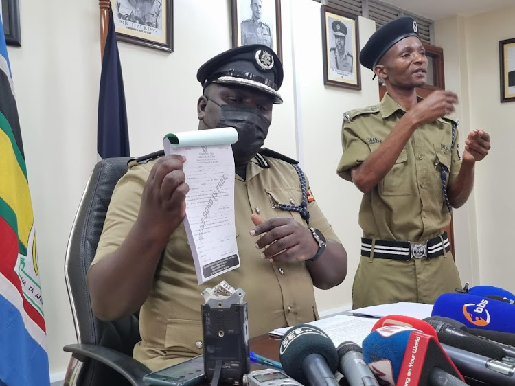 Police spokesperson Fred Enanga displays the new police bond receipt to the media in Kampala on Monday