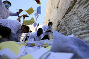 Men clear notes placed in the cracks of the Western Wall, Judaism's holiest prayer site, to make space for new notes ahead of the Jewish New Year, in Jerusalem's Old City August 25, 2021. 