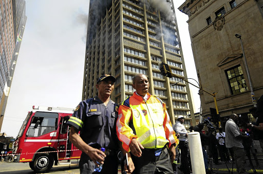 Johannesburg Mayor Herman Mashaba and Acting Fire Chief Executive Officer Arthur Mqwa in front of a burning building where three fire fighters died while trying to extinguish the fire.