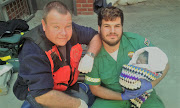 Kevin Jones, left, and Fabio Moreira with the baby they helped deliver at Table View Police Station on Thursday morning.