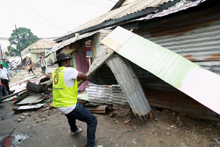 A KinBopete (Clean Kinshasa) team member tears down a pirate market shop as part of a campaign to clean up the Congolese capital ahead of Pope Francis' visit, scheduled for late January in Kinshasa, Democratic Republic of Congo, January 13, 2023.