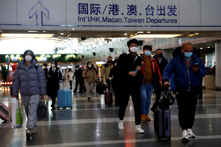 Travellers walk with their luggage at Beijing Capital International Airport on December 27 amid the Covid-19 outbreak in Beijing, China. Picture: REUTERS/TINGSHU WANG/FILE PHOTO