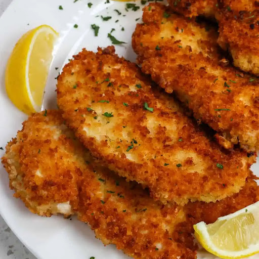 This Chicken Schnitzel recipe is breaded chicken cutlets pan-fried to golden crispy perfection while moist and tender on the inside. Serve with lemon wedges and chopped fresh parsley.  This easy recipe is prepared in less than 20 minutes.