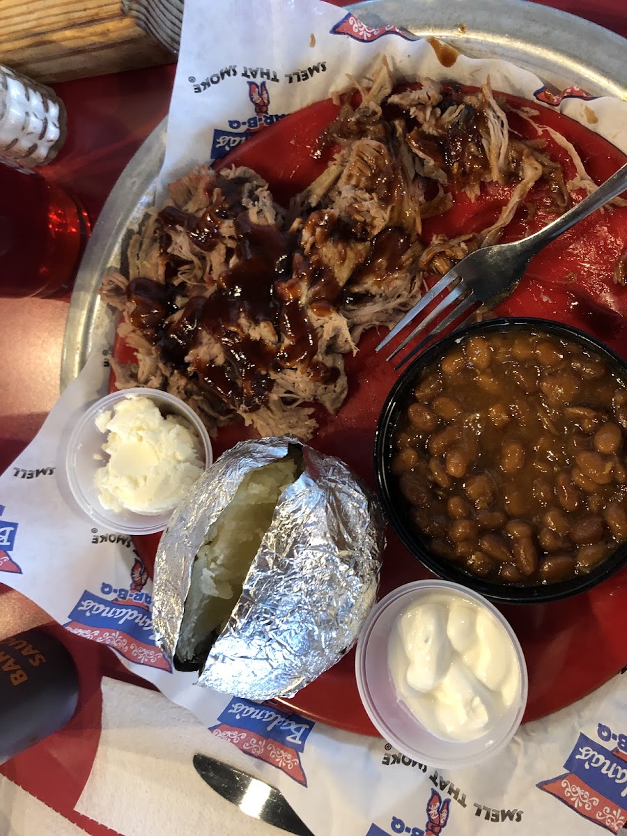 Gf Smoked pork, gf baked beans, baked potato, and delicious gf barbecue sauce.