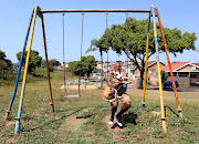 Russel Naidoo swings with Captain, a bull terrier, in Bayview. 