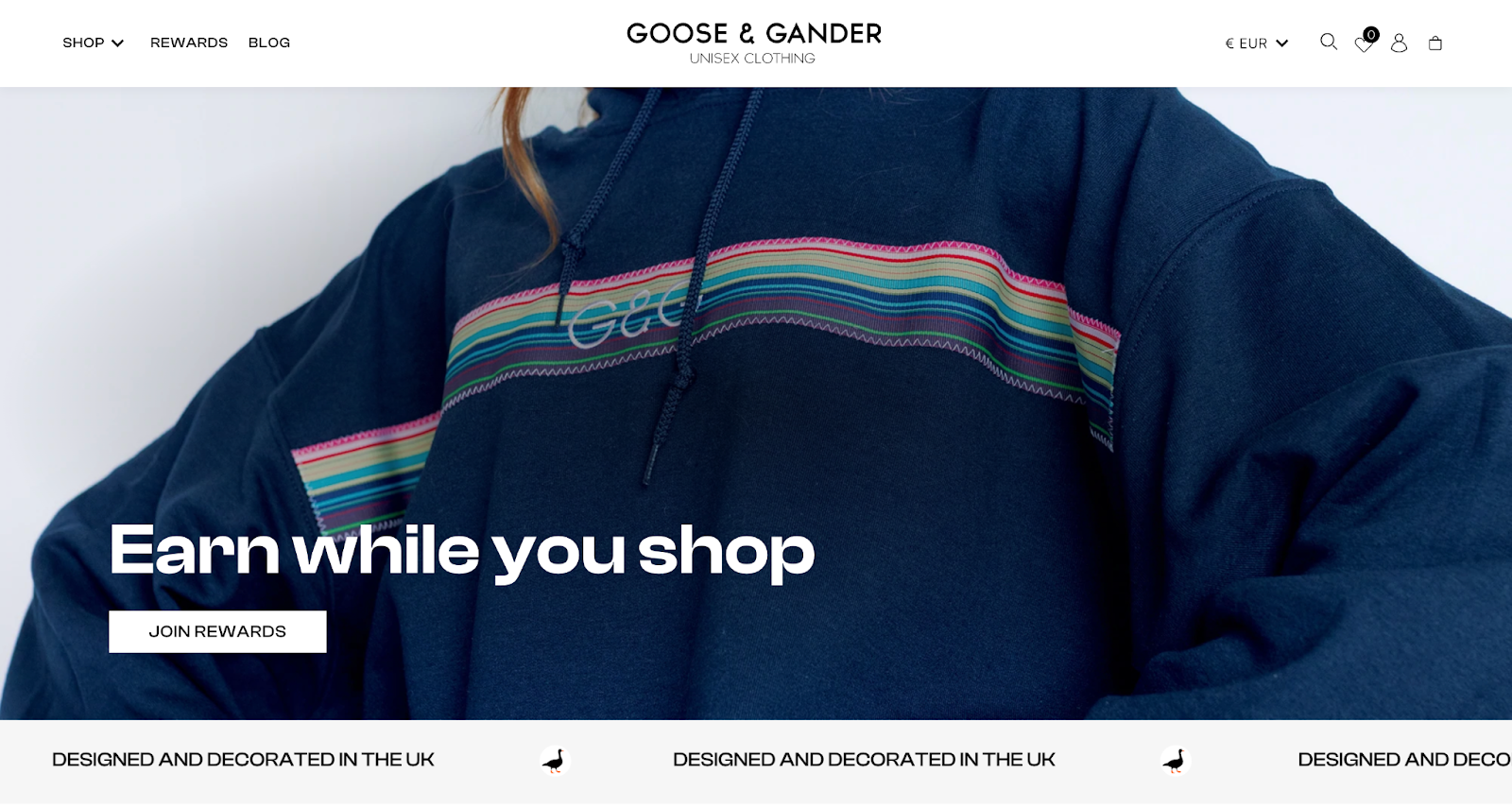 Ecommerce loyalty explainer page–A screenshot from Goose & Gander’s rewards explainer page with an image of a blue hoodie that has a rainbow stripe and text reading “Earn while you shop”. 