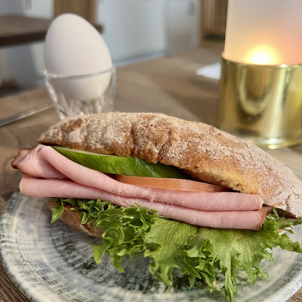 Breakfast sandwich and boiled egg.