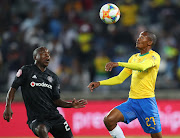 Orlando Pirates central midfielder Ben Motshwari (L) challenges for the ball with Mamelodi Sundowns right fullback Thapelo Morena (R) during an Absa Premiership match at Orlando Stadium in May 2019.