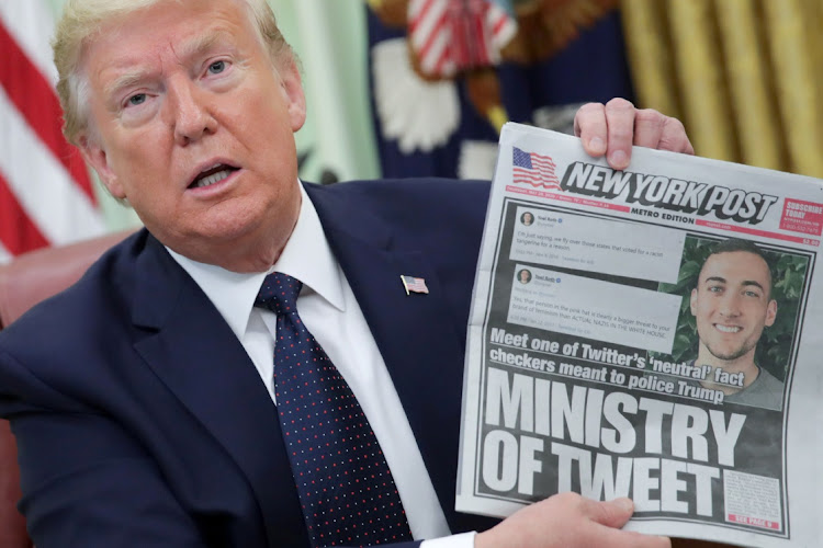 Donald Trump holds up the New York Post while discussing an executive order on social media companies when he was US president in May 2020. Picture: REUTERS/JONATHAN ERNST