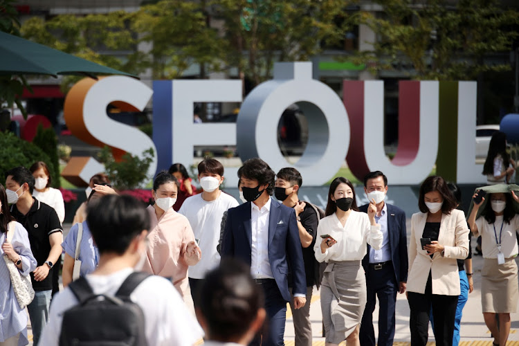 Commuters wearing masks to avoid contracting the coronavirus disease (Covid-19) walk on a zebra crossing in Seoul, South Korea, September 24, 2021.