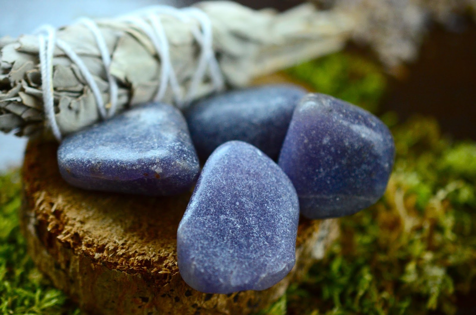 Dark blue lepidolite crystals next to a stick of sage.