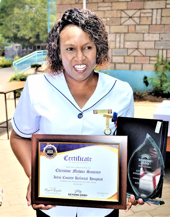 Kitui nurse Christine Mawia Sammy holds an award in March 2022.