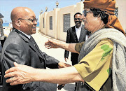 President Jacob Zuma is greeted by Muammar Gaddafi in Tripoli in 2010. 'Brother Leader's' money man, Bashir Saleh - who is on Interpol's wanted list - is in the background