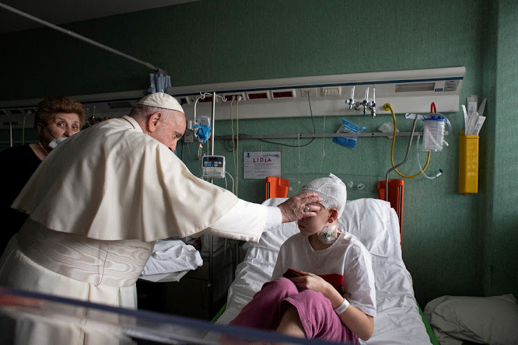 Pope Francis blesses an injured child who fled the Russian invasion of Ukraine, during a visit to the Bambino Gesu Children's Hospital in Rome, Italy, on March 19 2022. File photo.