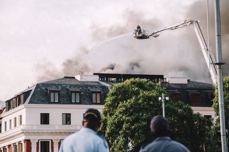 A reignited blaze at the parliament building had "completely engulfed" the roof, according to parliamentary spokesman Moloto Mothapo.