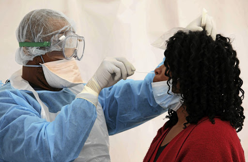 A health official wearing personal protective equipment tests a patient in the Western Cape. File photo.