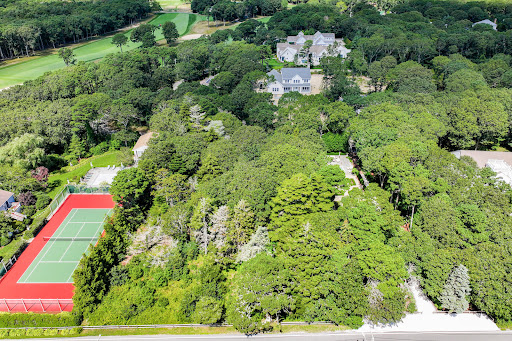 Aerial view wooded tennis court and houses in this luxury property for sale in Osterville ($3,000,000)