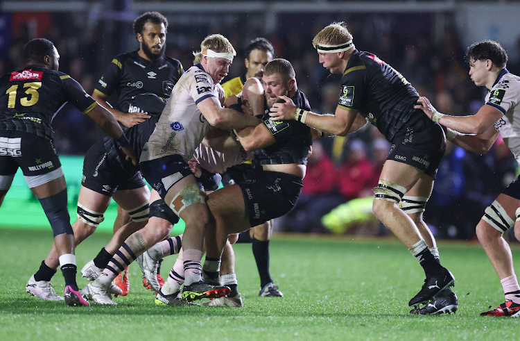 Hanro Jacobs of Sharks is held by Aaron Wainwright and Matthew Screech of Dragons on Sunday in Newport, Wales. Picture: GARETH EVERETT/HUW EVANS AGENCY/GALLO IMAGES