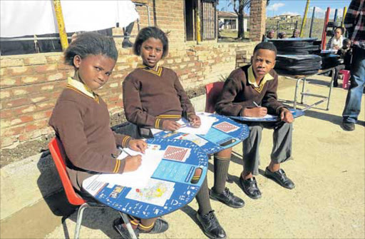 LEARNING WITH DIGNITY: Pupils, from left, Neliseka Bante, Olona Msenga and Sinalo Mkokeli from Makunga Mvalo Primary School in Nxaruni using their Tutudesks which were handed over to them yesterday Picture: ARETHA LINDEN