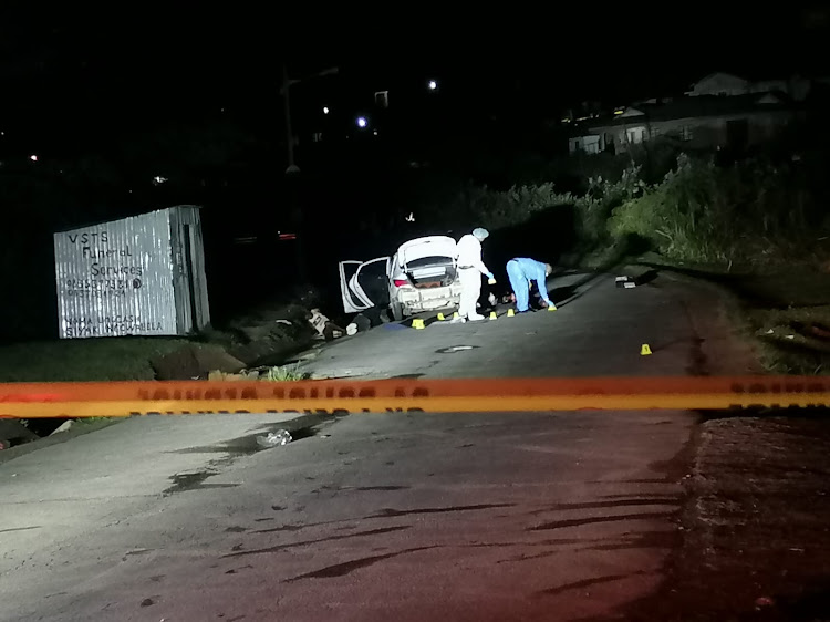 Forensic officers at a crime scene in Ntuzuma, outside Durban, after a shootout on Tuesday in which four suspects and one police officer was killed. A second policeman was injured.