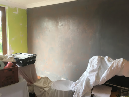 Wall prepared and painted ready for a dark mural paper to be applied.