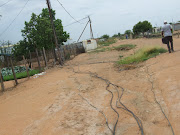 Illegally connected electrical cables lay exposed in the street, causing risk to the lives of children playing in the street.