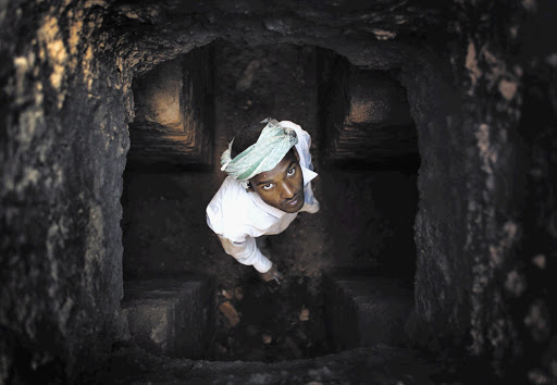 MY WIFE DOES THE WASHING: A worker peers up a chimney at a brick factory in Lalitpur, India, while renovating it