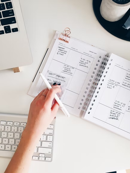 a person checking their schedule on a planner.