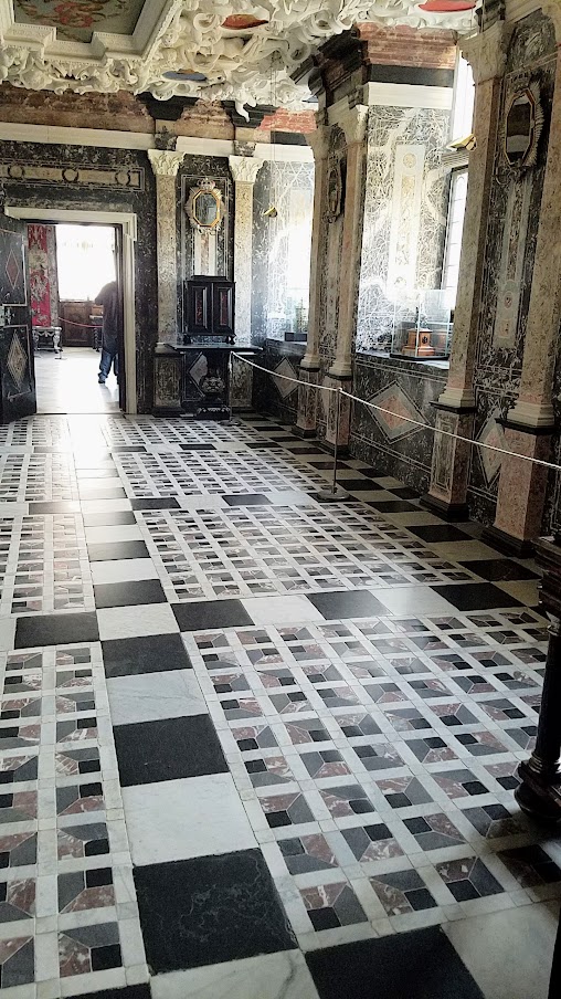 Visiting Rosenborg Castle in Copenhagen. This is the Marble Room - the ceiling paintings also show small, chubby, angelic child figures, carrying the Regalia and in the heart-shaped areas surrounding the paintings you can see parts of the Danish coat-of-arms and on the wall are the emblems of Norway, Denmark, and Sweden.