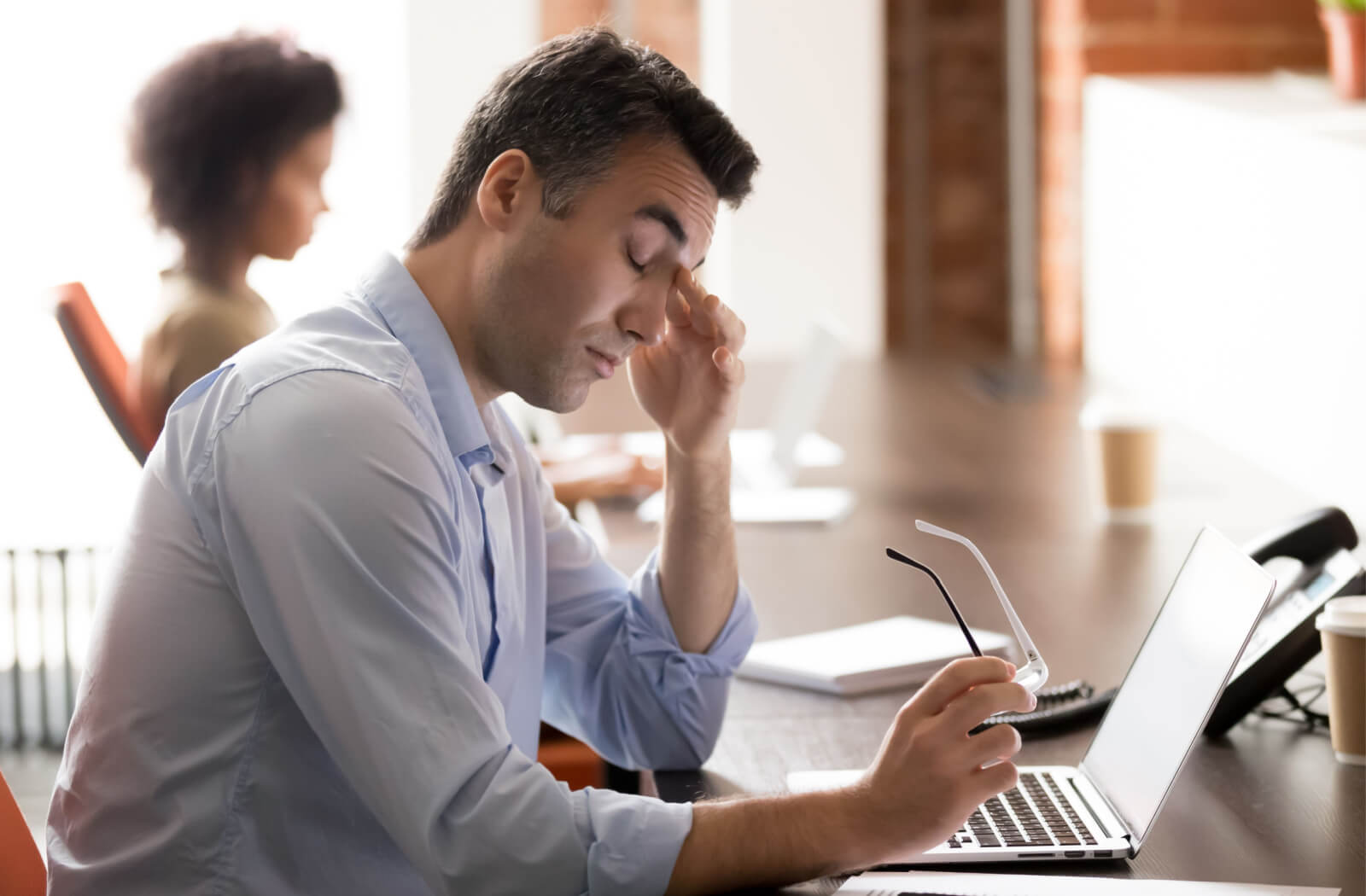 Middle-aged professional suffering from dry eyes due to prolonged exposure to a computer screen