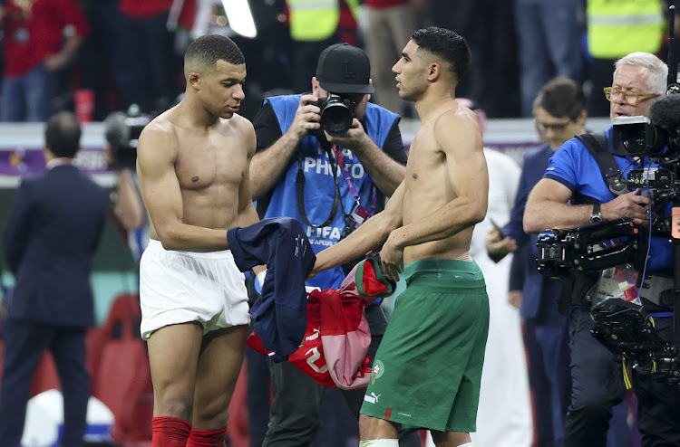 Kylian Mbappe of France and his friend and Paris St-Germain teammate Achraf Hakimi of Morocco exchange their jerseys after World Cup semifinal at Al Bayt Stadium in Al Khor, Qatar on December 14 2022.