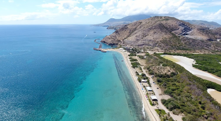 Drone image of the narrow beach and coastline of Frigate Bay in St. Kitts, looking north. 