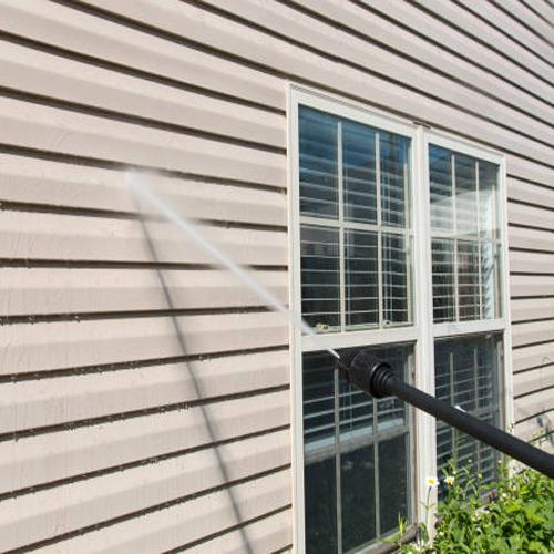 WeServe power washing the exterior of a house to remove the dirt