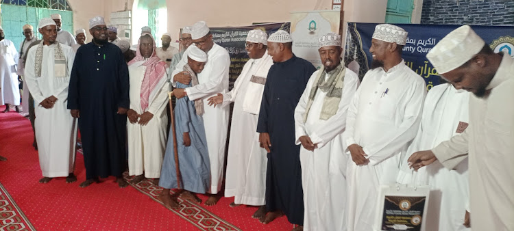 Defense Cabinet secretary Aden Duale congratulates Suheid Aden Hassan the overall winner in Garissa County Quran competition