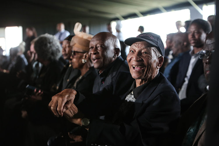South African Poet and writer Don Mattera, seated next to Welcome Msomi, share a light hearted moment at the funeral.