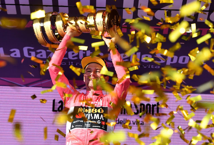 Visma's Primoz Roglic celebrates on the podium with the trophy after winning the Giro d'Italia's stage 21 in Italy, May 28 2023. Picture: JENNIFER LORENZINI/REUTERS