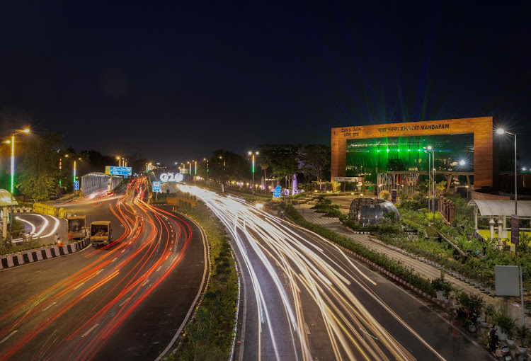 Traffic moves past a G20 logo installed in front of the main venue of the summit in New Delhi, India, August 25, 2023.