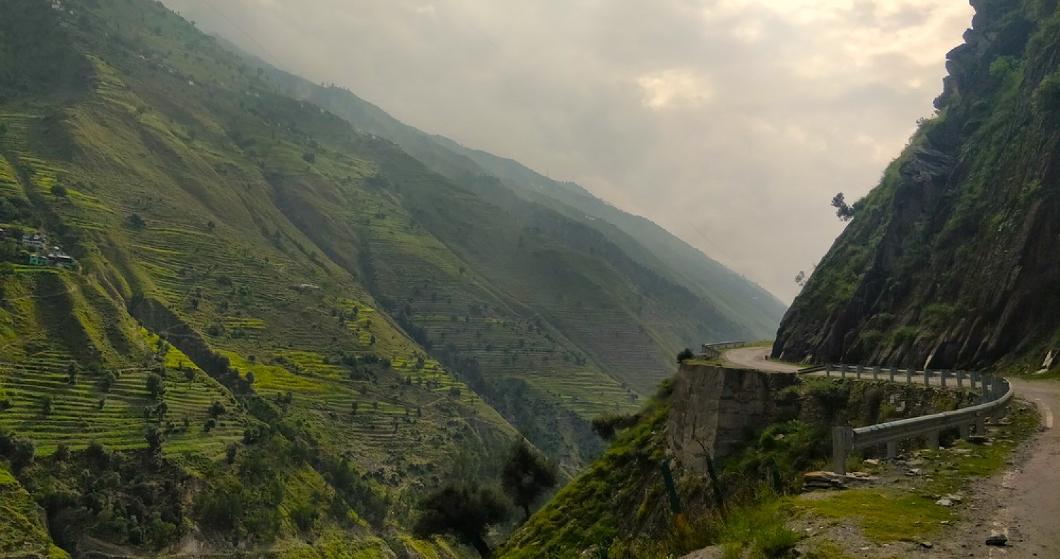 A group of trekkers on the way to Manimahesh Trek, surrounded by lush green mountains."