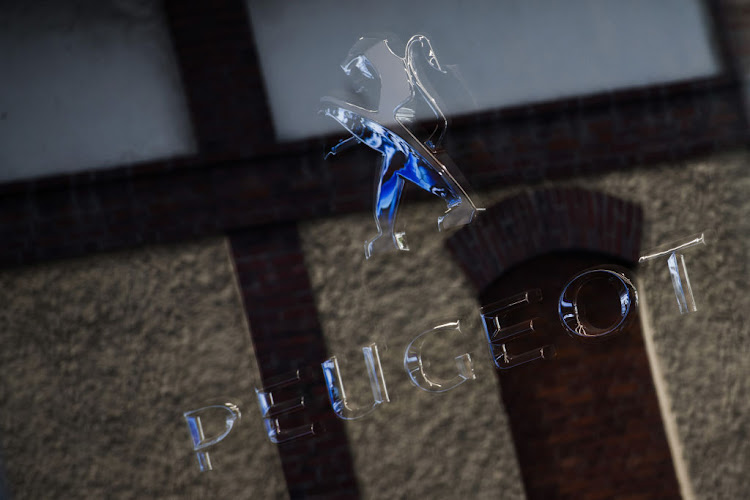 A Peugeot lion logo is reflected in the window of the PSA Retail Saint Didier automobile showroom, operated by PSA Group, in Paris, France, on Thursday, July 2, 2020. French car sales rose for the first time this year in a sign government incentives toward auto purchases are helping the sector claw back from a deep slump triggered by the coronavirus.