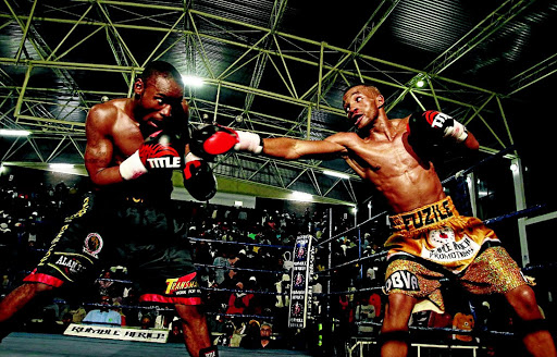 Rofhiwa Maemu tries to avoid a straight right from Azinga Fuzile during their SA featherweight bout at the Orient Theatre in East London on Sunday. / MICHAEL PINYANA