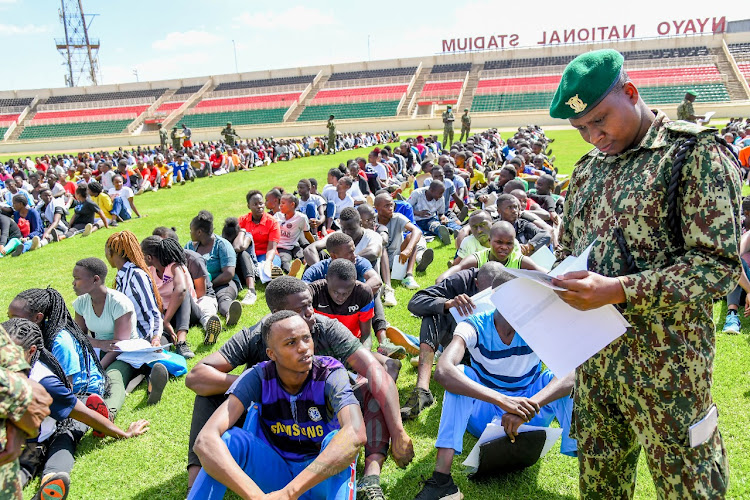 NYS officer examines documents of youth who turned out for the NYS recruitment at the Nyayo stadium in Nairobi on February 9, 2024.