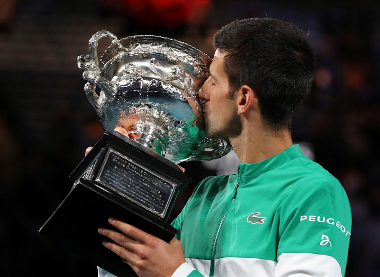 Serbia's Novak Djokovic celebrates with the trophy after winning his ninth Australian Open title at Melbourne Park on February 21, 2021.