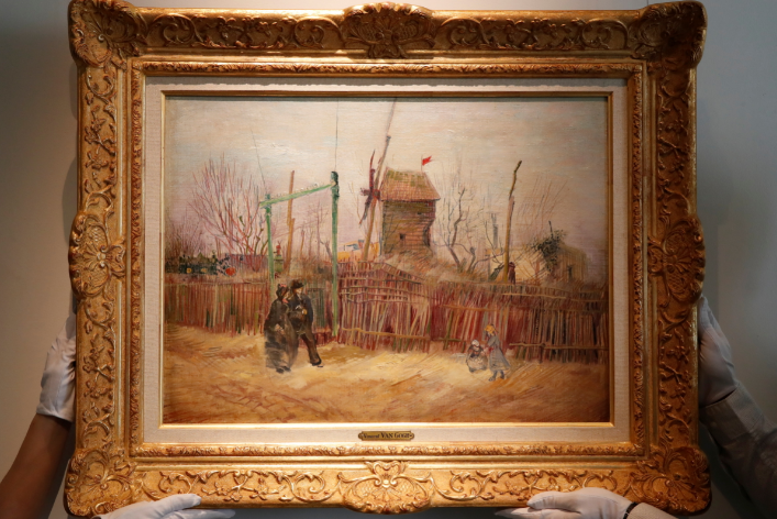 Sotheby's Paris employees pose with the 1887 painting of a Paris street scene "Scene de rue a Montmartre" by Dutch painter Vincent Van Gogh which will be presented to the public for the first time after spending more than a century behind closed doors in the private collection of a French family, France, on February 24, 2021.