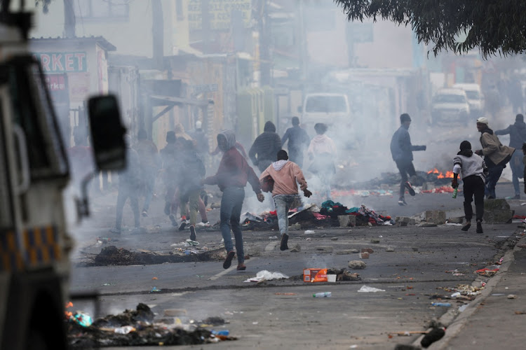 Protesters in Masiphumelele clash with Cape Town law enforcement officials during a strike by taxi operators against traffic authorities on August 8 2023.