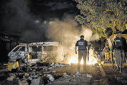 NIGHTFALL: Metro police watch for any activity on Pokela Road, Masiphumelele, late on Friday night after a day of violent protests